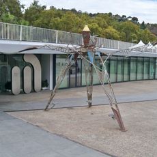 Escultura realizada con materiales reciclados en forma de pulpo gigante, con patas de acero y elementos que representan a la gente del mar. Originalmente contaba con tres bicicletas cuyo pedaleo generaba electricidad para iluminar la escultura.