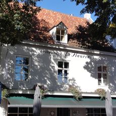 Huis onder zadeldak tussen zij-topgevels, gepleisterde voorgevel