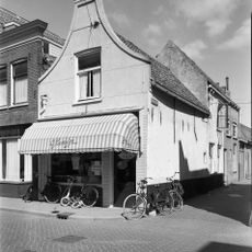 Hoekpand met gepleisterd tuitgeveltje en driehoekig fronton