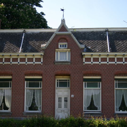 Boerderij, bestaande uit een woonhuis met aangebouwd bedrijfsgedeelte, gebouwd op een kunstmatige verhoging. In de gevel van het huis zijn elementen van Neo-Renaissance verwerk