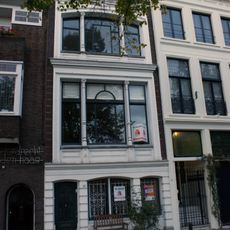 Pand met gepleisterde lijstgevel met rijk stucwerk opgesmukt