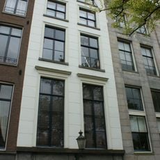 Pand met gepleisterde gevel onder rechte lijst met reeks consoles