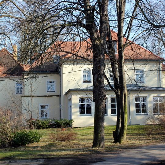 Herrenhaus über winkligem Grundriss, Gutspark und umgebende Einfriedungsmauer mit drei Torzugängen eines ehemaligen Rittergutes sowie Aussichtspunkt mit Linde an der Kamenzer Straße Parkstraße 11, 13