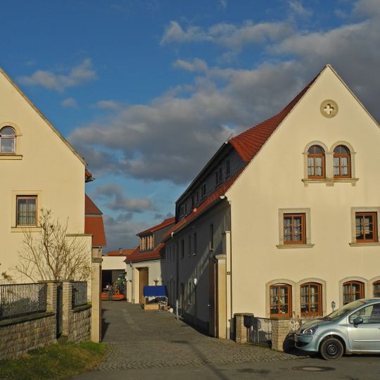 Wohnstallhaus, Scheune und Seitengebäude eines Dreiseithofes Dorfplatz 12