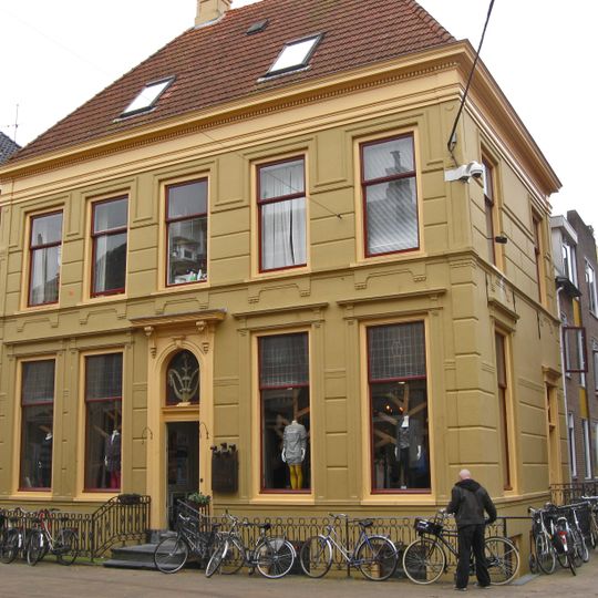 Bepleisterd pand met hekwerk