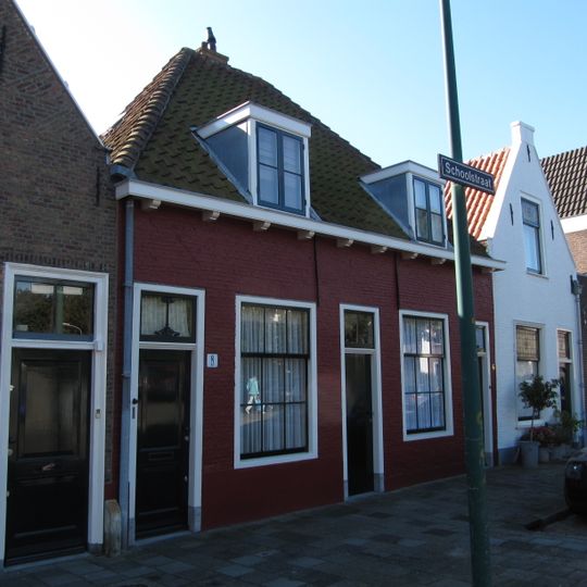 Pand zonder verdieping. Hoog schilddak met de nok evenwijdig aan de straat