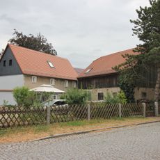 Wohnhaus und Seitengebäude eines Zweiseithofes mit Hofpflasterung Dorfplatz 10