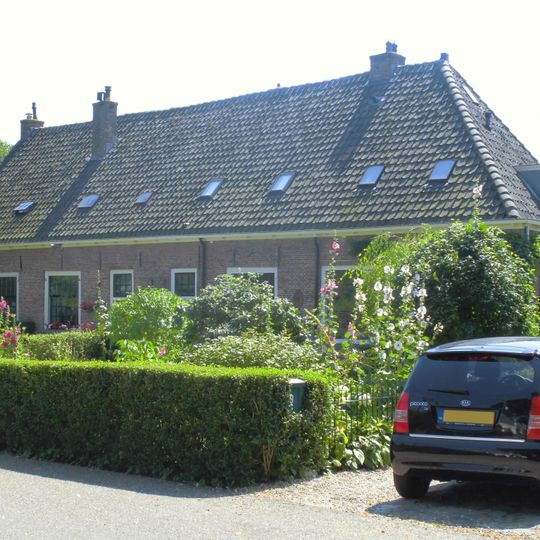 Pand met langgerekte lage gevel met zadeldak en rechte kroonlijst