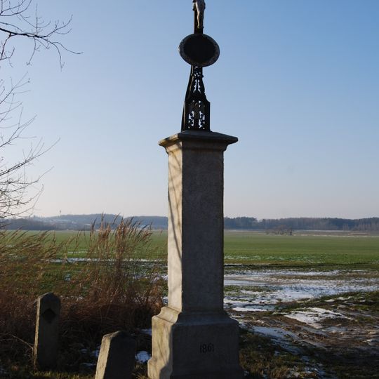 Křížek na kamenném podstavci západně od Munic