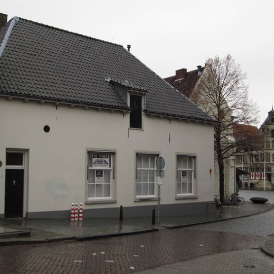 Laag pand met hoog zadeldak en gepleisterde lijstgevel