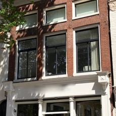 Even hoog pand als nr. 1 met geblokte kroonlijst waarboven halfronde gesloten dakkapel