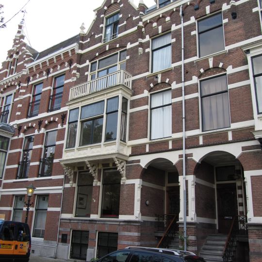 Pand in neo-renaissance trant met links topgevel. Brede houten erker op korbelen. Gevelversiering met banden en blokken. Rechts getoogde ingangspartij