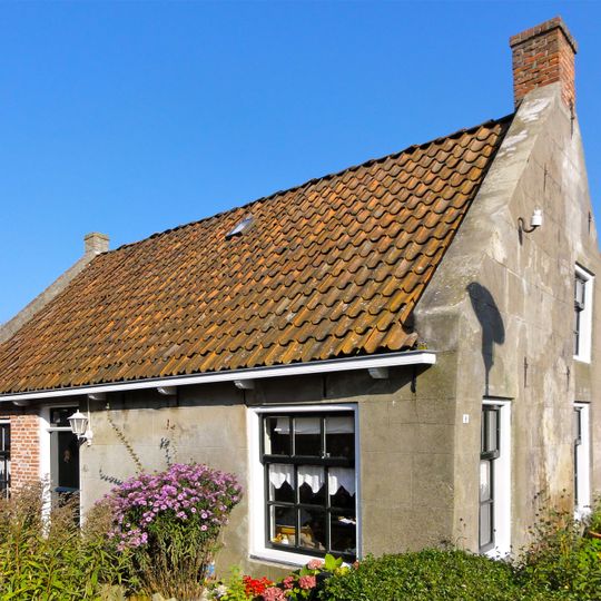 Woning met zesruitsvensters onder zadeldak tussen gepleisterde topgevels