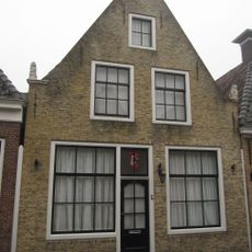 Pand onder zadeldak tegen gepleisterde topgevel