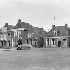 Eenvoudig pand met stervormig bovenlicht boven de deur onder zadeldak tegen puntgevel met vlechtingen en daklijsten