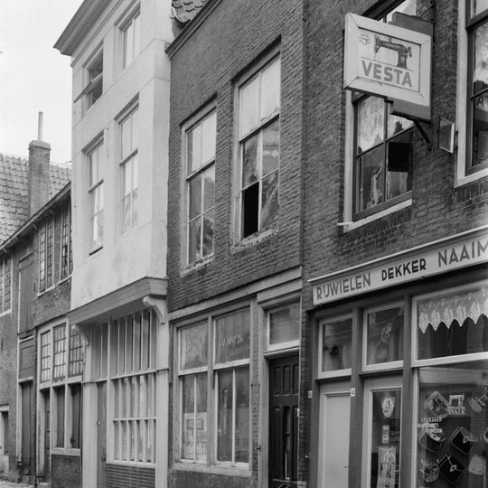 Huis met eenvoudige lijstgevel, winkelpui met middendeur