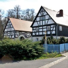 Schmiede, Wohnhaus und Torbogen eines Schmiedeanwesens sowie Betkreuz Zur Schmiede 7
