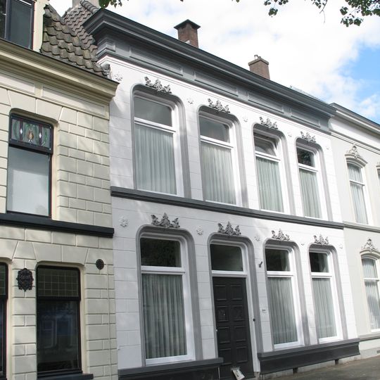 Pand met gepleisterde lijstgevel onder twee evenwijdige schilddaken met hoekschoorstenen