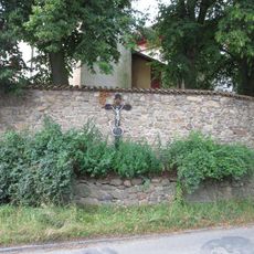 Kříž u kostela na zdi v Neveklově
