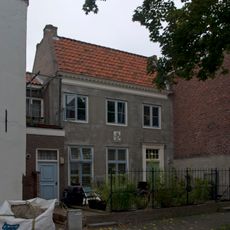 Apart genummerde ingang in gepleisterde zijgevel van het pand Korte Noordstraat 2