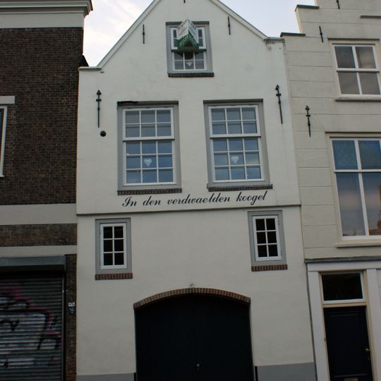 Pand met tot puntgevel gewijzigde trapgevel met sierankers en luiken