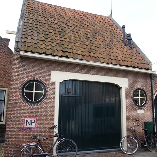 Tot pakhuis gedegradeerd pandje onder zadeldak tussen topgevels