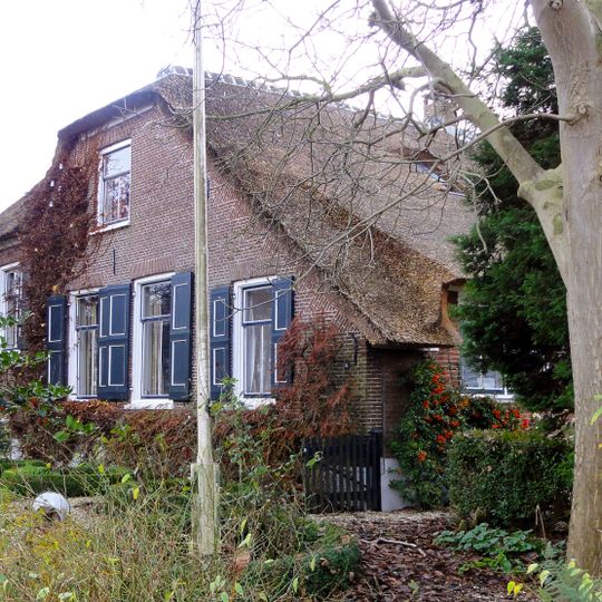 Grote boerderij met in de 19e eeuw vernieuwde voorgevel