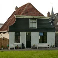 Groot pand met afgeknot ingezwenkt houten voorschot