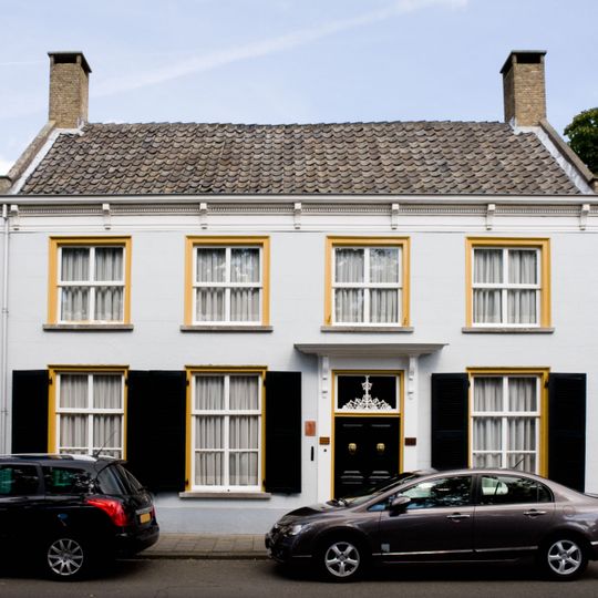 Huis met zadeldak en zijtopgevels met vlechtingen, ingang met kroonlijst op voluutvormige consoles