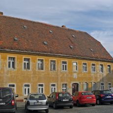 Wohnhaus in halboffener Bebauung, zwei Nebengebäude und Einfriedungsmauer mit Torbogen Am Markt 5