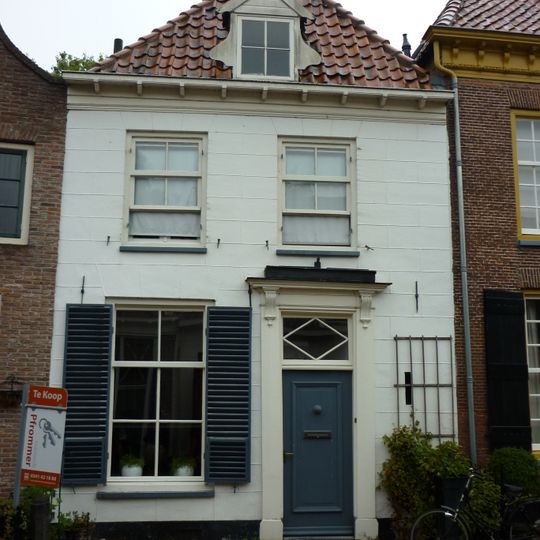 Pand onder hoog schilddak, waarin een dakkapel met fronton en zijstukken