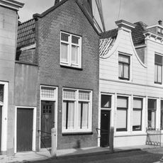 Huis met gepleisterde klokgevel met lijstje