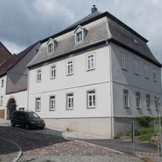 Pfarrhaus mit westlichem Torbogen und östlicher Stützmauer mit Einfriedung sowie rückwärtiger Stützmauer an der Otto-Altenkirch-Straße Kirchgasse 3