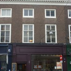 Pand met gevel in Lodewijk XIV-stijl, geheel gemoderniseerde onderpui, inwendig enkele stucplafonds in Lodewijk XV-stijl