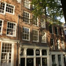 Pand met halsgevel met gelobde afdekking waaronder beeldhouwwerk