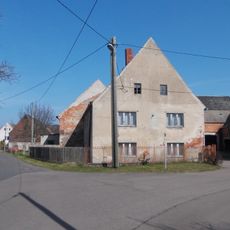 Wohnhaus (ohne Stallanbau), östliche Scheune und südliches Seitengebäude mit Auszugshaus eines Dreiseithofes sowie Hofpflaster Elbaue 23