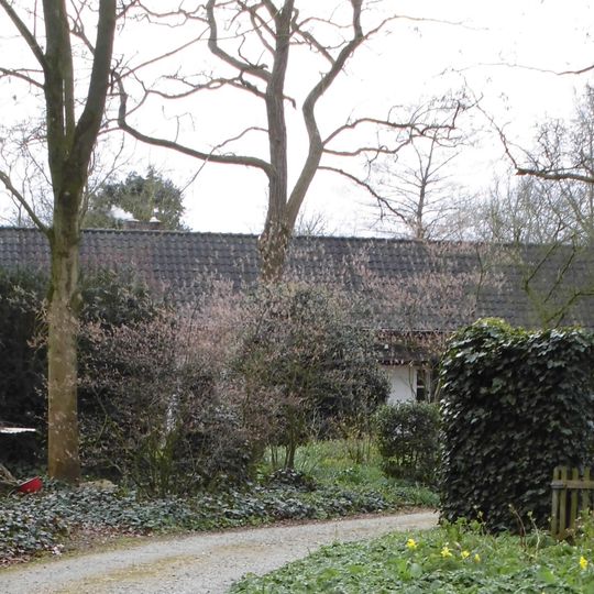 Schuur, bestaande uit een korte en een lange beuk, op stenen onderbouw, opgetrokken van gepotdekselde houten delen en gedekt met pannen zadeldaken