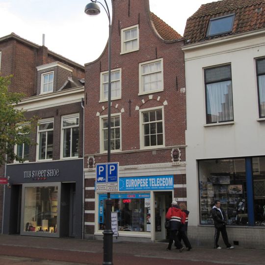 Pand met klokgevel, voorheen trapgevel, toegespitste bogen boven vensters met natuurstenen blokken, grote leeuwenmaskers