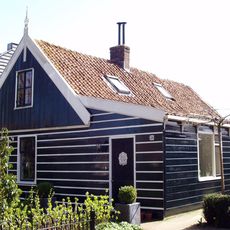 Houten huis met aangebouwde zijbeuk aan de rechterzijde en puntvormig voorschot