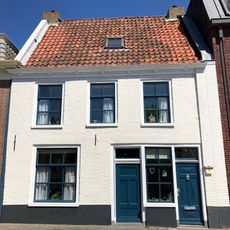 Pand onder dwarsgedekt zadeldak tussen topgevels