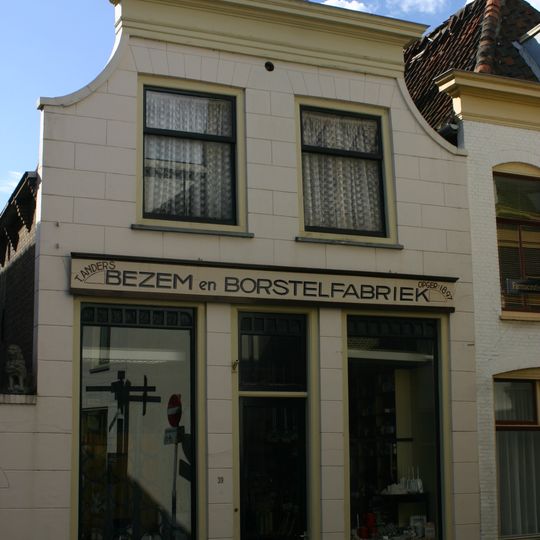 Pand met aan de voorzijde gewijzigde en gepleisterde gevel met inzwenkende zijkanten en houten kroonlijst