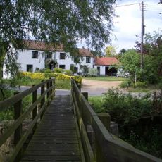 Footbridge at W end of village