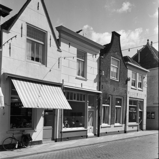 Huis met tot gepleisterd tuitgeveltje met rollaag gewijzigde trapgevel