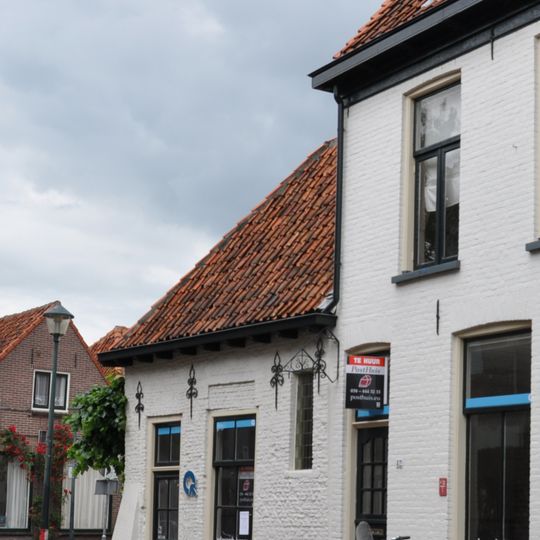 Klein, gepleisterd huisje onder pannen schilddak