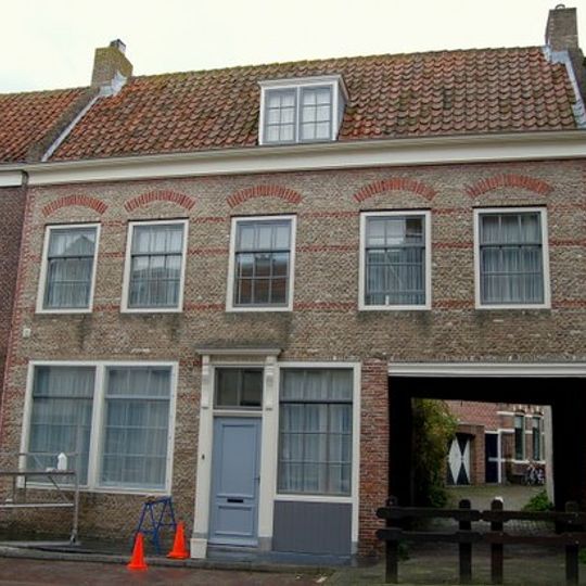 Huis met brede gecementeerde rechte gevel