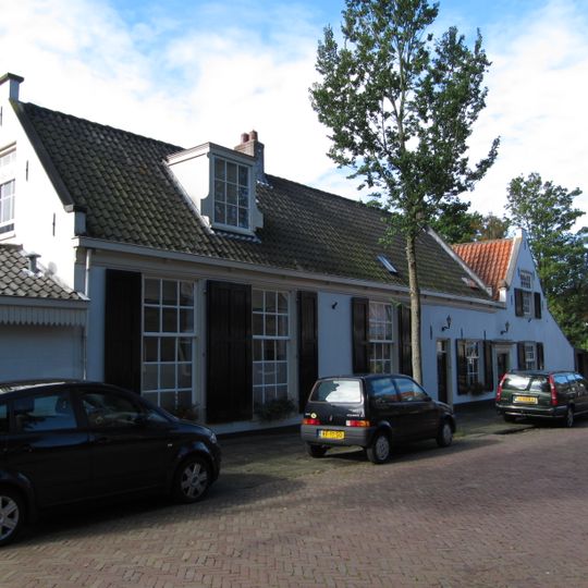 Lage gecementeerde woning met schuiframen en roedeverdeling vensters