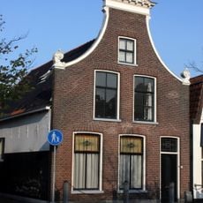 Pand onder zadeldak tegen door fronton bekroonde klokgevel