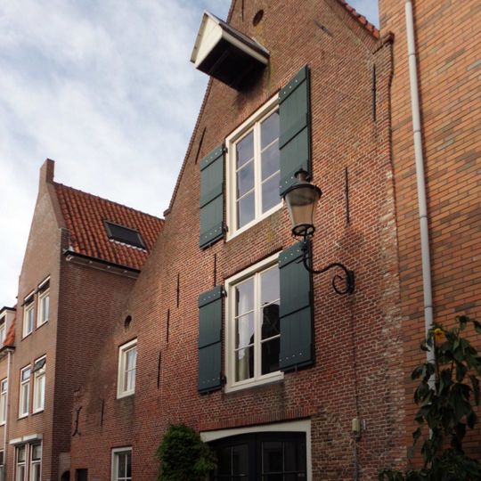 Pakhuis met topgevel, uitgevoerd in baksteen. Hijsbalk. Vormt een geheel met nr 30