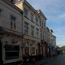 Huis met gebosseerd gepleisterde lijstgevel, nog geheel woonhuis