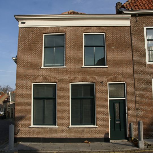 Woonhuis met eenvoudige lijstgevel. Stoep met paal. Hoekpand Kaatsbaan